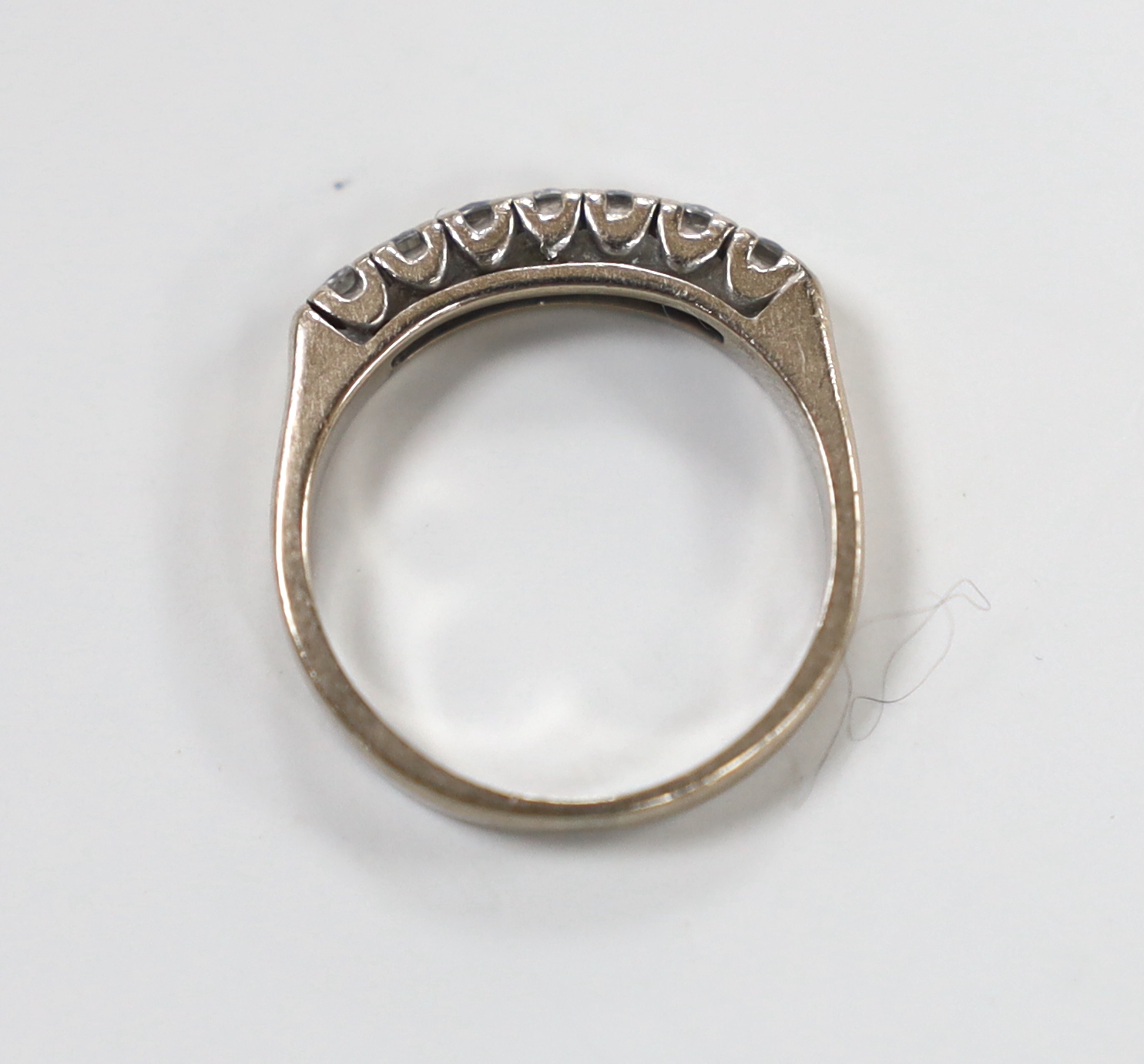A modern white metal and seven stone diamond set half eternity ring, size L/M, gross weight 4.2 grams.